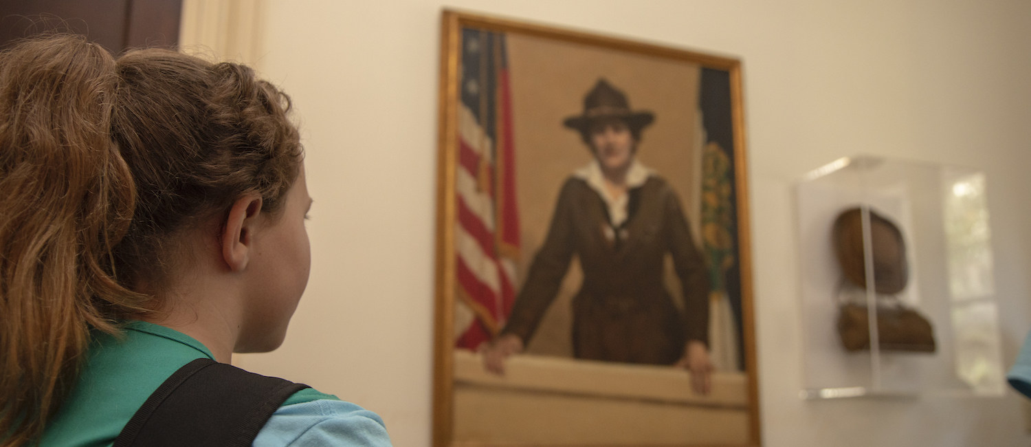 Girl Scout looking at a picture of Juliette Gordon Low in the Juliette Gordon Low Birthplace
