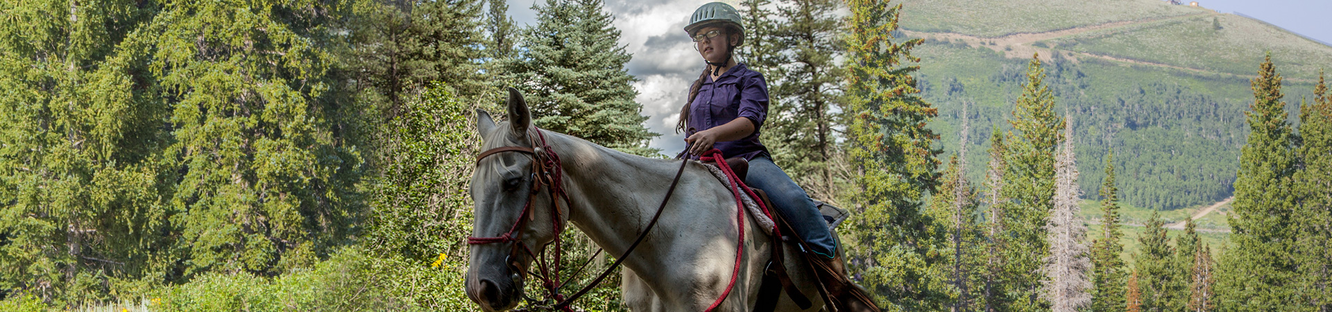  girl riding a horse through the mountains 