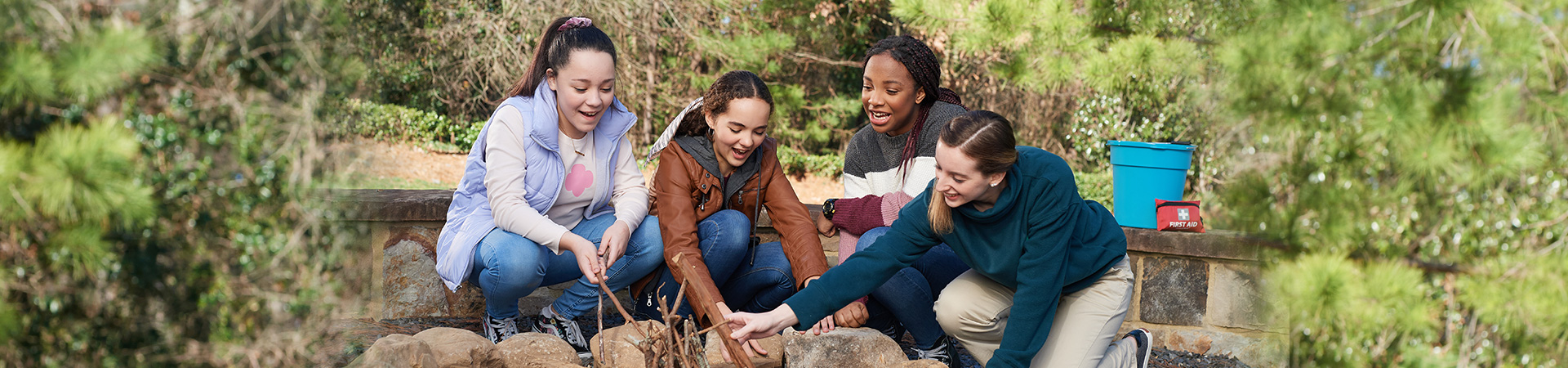  four girls building a campfire 