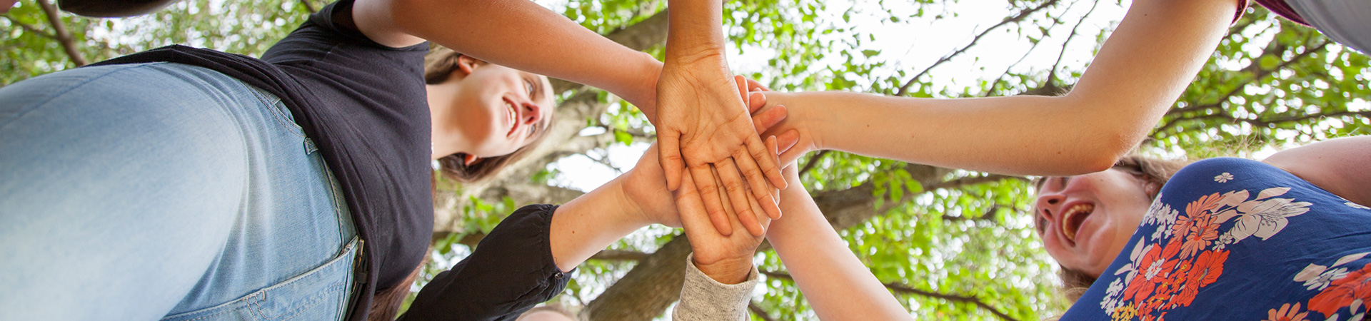  Group of high school Girl Scouts holding hands in a team circle. 