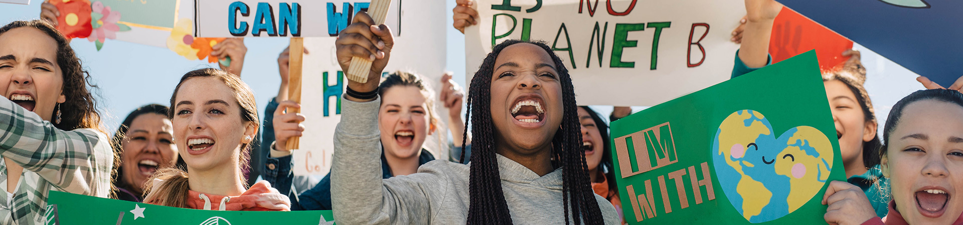  group of high school girl scouts at protest outside holding signs that read "I'm with earth" and "There is no planet b" 