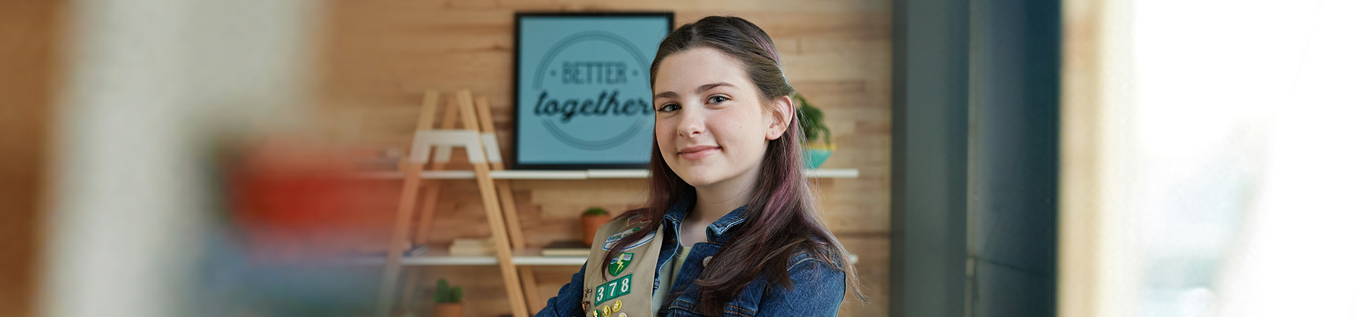  Cadette girl scout with her arms crossed smiling at the camera 