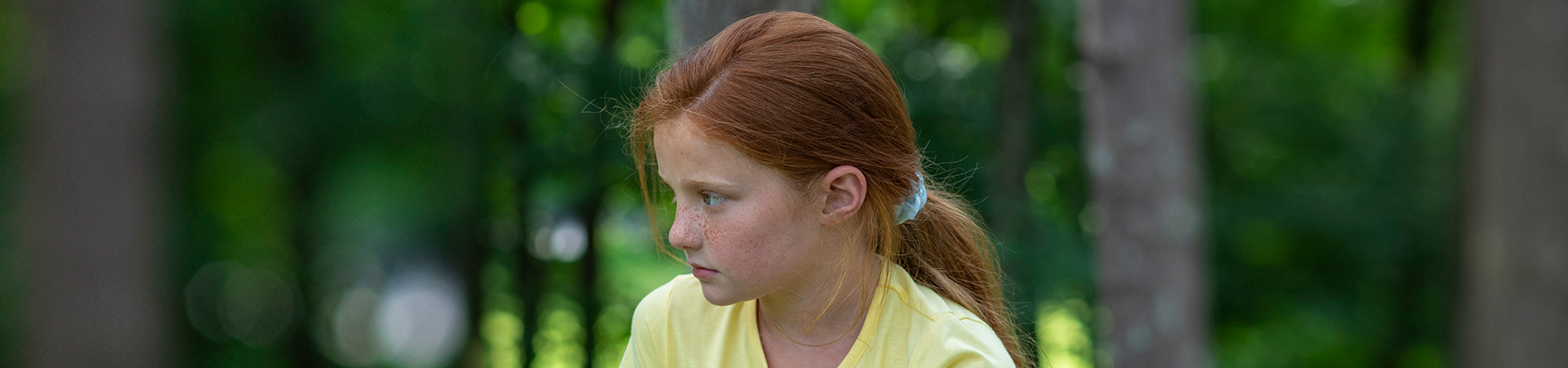  Young elementary school daisy brownie Girl Scout looking away with serious facial expression. 