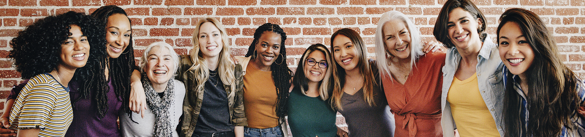  Group of Girl Scout alums with their arms around each other, smiling at the camera 