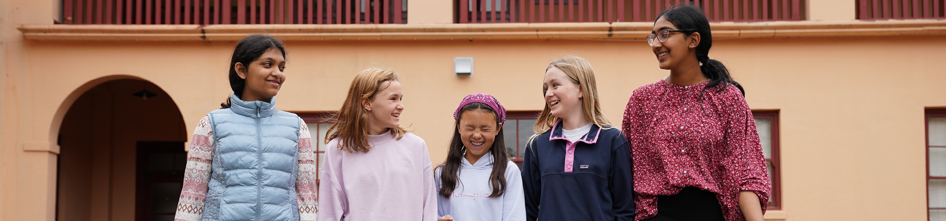  group of girl scouts walking outside smiling at each other 